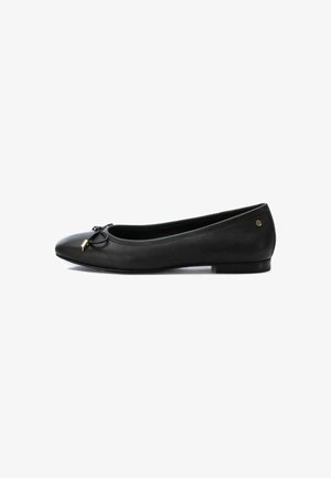 Bailarina de cuero negro con punta redonda, que presenta un lazo decorativo y un detalle en dorado. Textura suave y tacón bajo.
