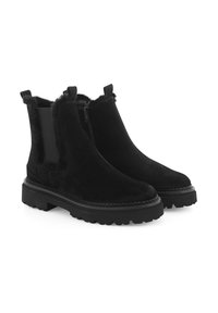 Zwarte enkelboots van suede met een schapenvacht afwerking, een ritssluiting aan de zijkant en robuuste rubberen zolen. Voorzien van een treklus aan de hak.