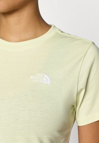 Ανοιχτό κίτρινο βαμβακερό μπλουζάκι με κοντά μανίκια, με λευκό κεντημένο λογότυπο στην αριστερή πλευρά του στήθους. Μαλακή υφή και στρογγυλή λαιμόκοψη.