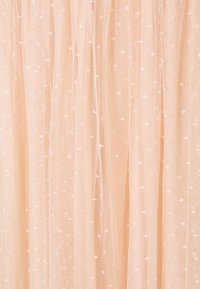 Weicher, pfirsichfarbener transparenter Stoff mit zarter kleiner Blumenstickerei und subtilen Falten, die eine leichte, luftige Textur erzeugen.