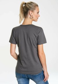 Graues Baumwoll-T-Shirt mit kurzen Ärmeln, rundem Halsausschnitt und glatter Textur, kombiniert mit blauen Jeans. Rückansicht.