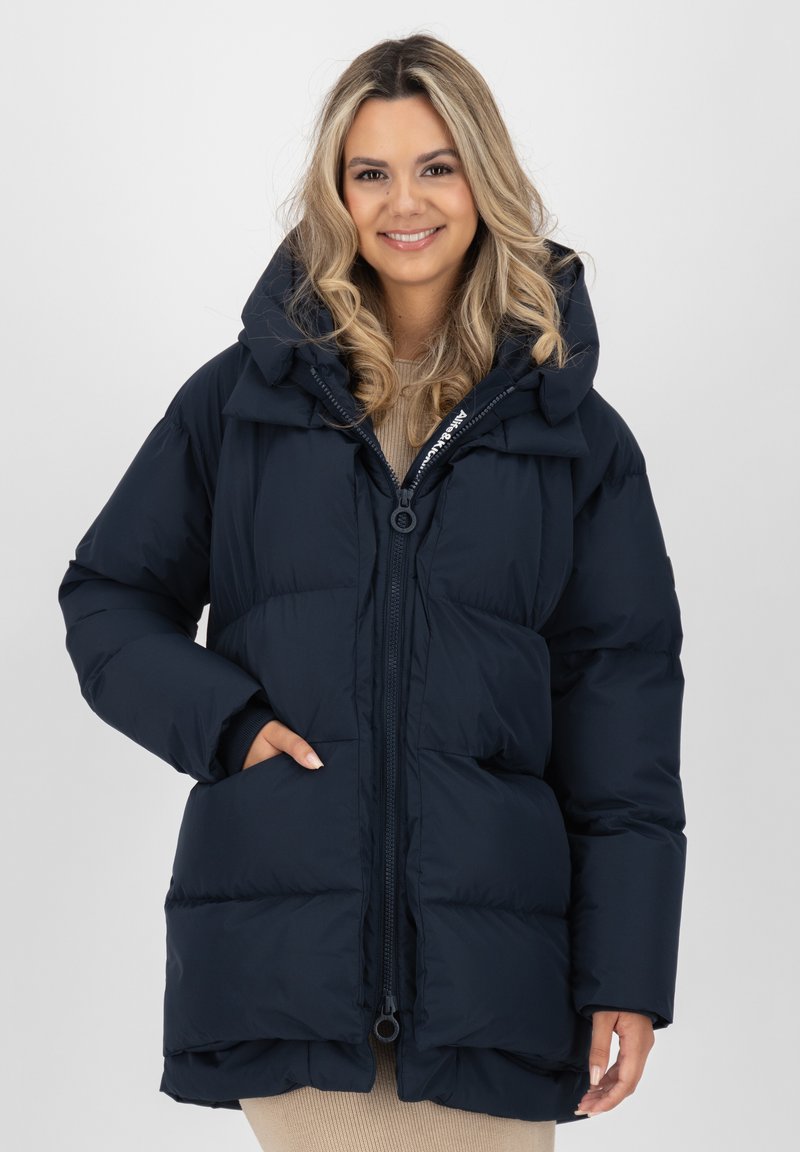 Giubbotto imbottito blu scuro con colletto alto e grande cappuccio, dotato di chiusura con zip, tasche laterali e un design trapuntato per l'isolamento.
