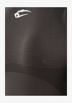 Gros plan sur un tissu sombre texturé avec un petit motif en maille et un logo blanc stylisé en forme de griffe ou patte d'animal près du coin supérieur gauche.