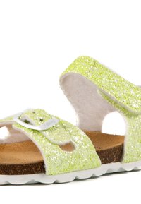 Sandales scintillantes vert clair avec des sangles réglables, une semelle en liège marron et une semelle en caoutchouc blanc présentant des détails découpés.