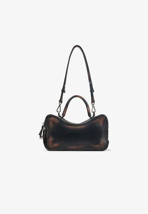 Borsa in pelle nera e marrone con un design curvo e raffinato. Presenta un manico superiore e una tracolla regolabile. Chiusura con zip e un elegante pon-pon decorativo.