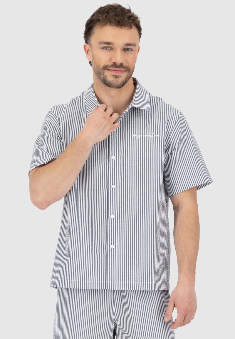Short-sleeve, collared shirt in blue and white vertical stripes, featuring front buttons and chest logo, made from lightweight fabric.
