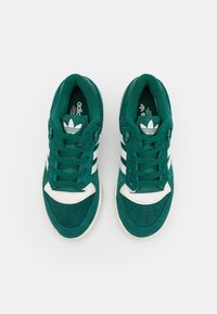 Gröna mockaskor med vita detaljer och tre ränder. Utrustade med en vadderad tunga, snörningsdesign och perforerat tåparti för andningsförmåga.