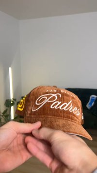 Cappellino da baseball marrone in velluto a coste con scritta "San Diego Padres" ricamata in bianco, con dettagli logo sul lato e visiera arrotondata.