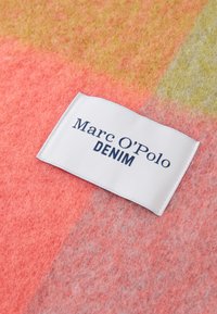 Tunde kangas roosa ja oranži tooni, millel on valge silt, kus on kirjas "Marc O'Polo" ja "DENIM." Pehme tekstuur koos peene gradatsioonimustriga.