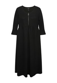 Schwarzes Kleid aus weichem Stoff, mit rundem Ausschnitt und einem Reißverschluss auf der Vorderseite mit einem runden Ziehpul. Ausgestellter Saum und Dreiviertelärmel.