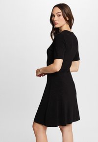 Zwart kortmouwige jurk met een aansluitend lijfje en een uitlopende rok, gemaakt van gladde stof. Kenmerkt zich door een klassieke ronde halslijn en minimale stitching.