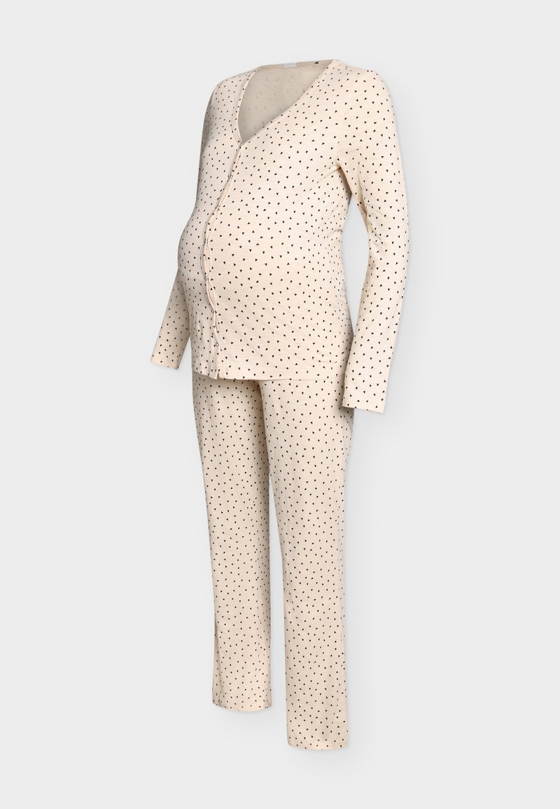 Ensemble pyjama de maternité beige à petits pois noirs, composé d’un haut à manches longues boutonné et d’un pantalon assorti sur un mannequin.