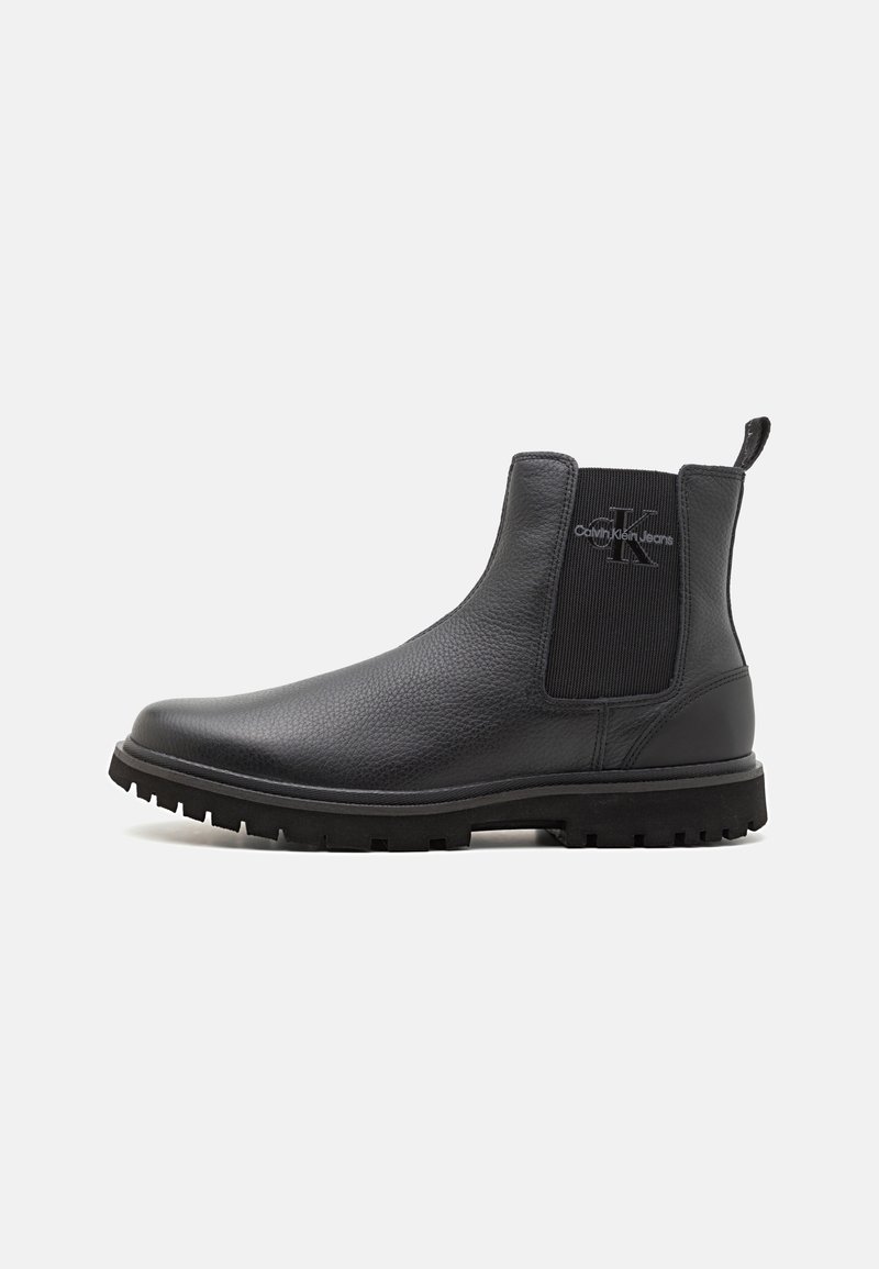 Bottine noire en cuir avec panneau latéral élastique et logo Calvin Klein Jeans sur le côté extérieur, munie d’une semelle à crampons pour l’adhérence.