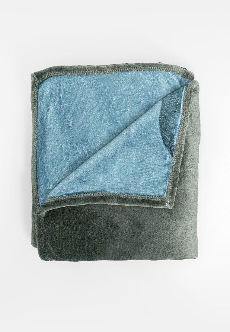 Zacht pluche deken gevouwen, donkergroene buitenkant, lichtblauwe binnenkant met subtiel textuurpatroon.