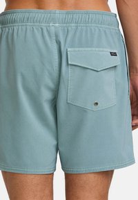 Zwemshorts voor mannen in lichtblauwe stof met een textuurafwerking, met een achterzak met een klep en een metalen oogje.