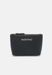Pochette en cuir noir avec une finition texturée, présentant une fermeture éclair dorée et un logo "VALENTINO" en relief à l'avant. Design compact, forme rectangulaire.