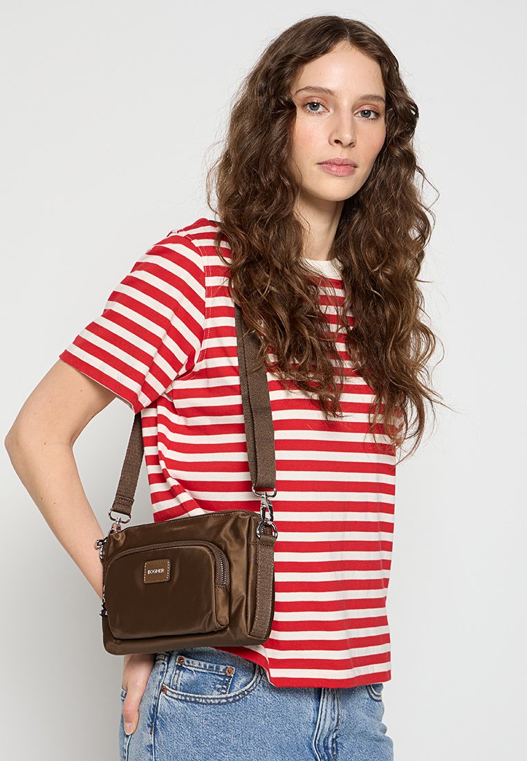 Borsa a spalla in nylon marrone con tasca con zip, tracolla regolabile marrone, forma rettangolare, indossata sulla spalla sopra una maglietta a righe rosse e bianche.