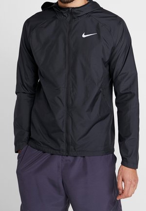 Schwarze leichte Nike-Jacke mit Reißverschluss vorne, Kapuze und strukturierter Oberfläche. Sie verfügt über ein dezentes Logo auf der linken Brust und elastische Bündchen.