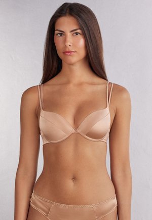 Nude satijnen bh met beugels, voorgevormde cups en dunne verstelbare bandjes. Glad materiaal en minimale details voor een stijlvolle uitstraling.