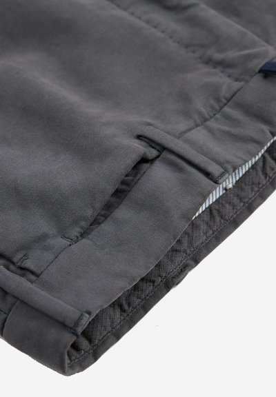 Pantalons pour hommes gris foncé en tissu lisse, avec un ourlet replié et une doublure intérieure texturée. Les caractéristiques incluent des passants de ceinture et des détails à motif à carreaux subtils.