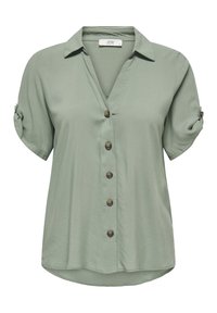 Camicia verde chiaro a maniche corte con scollo a v, chiusura con bottoni e maniche arrotolate. Realizzata in tessuto liscio, presenta bottoni rotondi lungo il davanti.