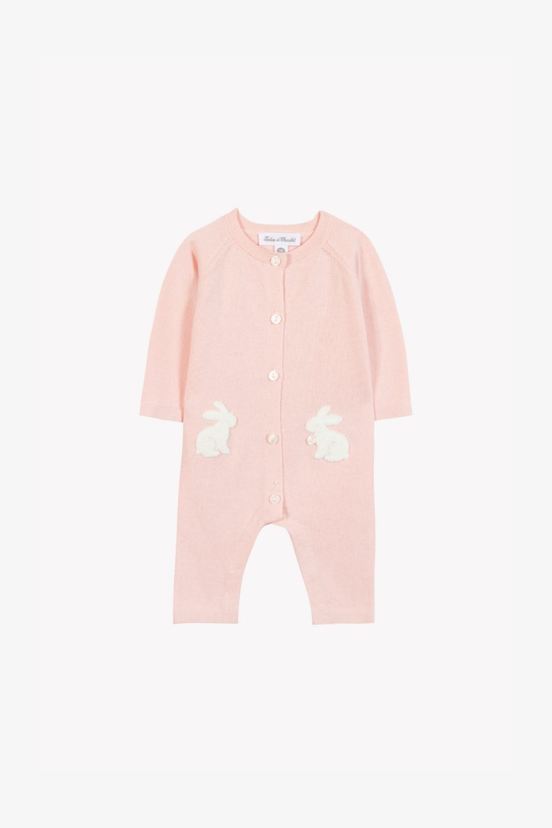 Różowy, dziergany kombinezon niemowlęcy z długimi rękawami, ozdobiony białymi, puszystymi aplikacjami króliczków na kieszonkach oraz zapięciem na guziki z przodu.