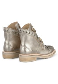 Bottines métalliques dorées avec cuir lisse, œillets décoratifs, lacets à l'avant et un léger talon en bois. Comprend une fermeture éclair et des détails accentués.