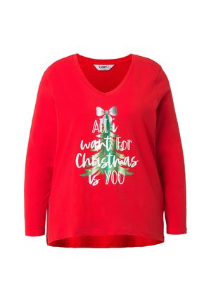 Maglietta a maniche lunghe rossa con scollo a V, decorata con testo natalizio bianco e verde e un motivo di fiocco argentato. Realizzata in cotone morbido e leggero.