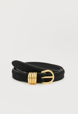 Cinturón con textura de pelo negro enrollado con hebilla de metal dorado y cuatro pasadores dorados sobre un fondo blanco.