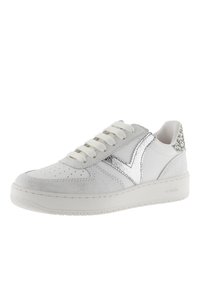 Baskets blanches avec une tige en cuir texturé, accents argentés et un talon en daim. Présentent un design à lacets et un bout perforé pour une meilleure respirabilité.