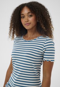 Gestreiftes Baumwoll-T-Shirt mit blauen und weißen horizontalen Linien, gerippter Textur sowie gewellten Ausschnitt- und Ärmelkanten.