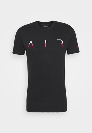 T-shirt noir à manches courtes avec des lettres stylisées en dégradé rouge et blanc formant "AIR" sur la poitrine et un petit logo sur la manche gauche.