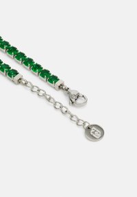 Green crystal bracelet featuring silver-tone hardware, lobster clasp, and a chain link extension with a logo charm.