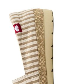 Calzature a strisce beige e crema con dettagli in juta intrecciata, dotate di suola in gomma e una patch rossa con logo sul lato.
