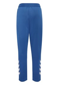 Pantalon de sport bleu avec taille élastique et bandes en chevrons blanches le long des jambes extérieures basses, vue de dos.