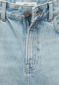 Světle modré džíny z denimu s předním zipem, zavíráním na knoflík a kontrastním šitím. Tkanina má jemný, strukturovaný vzhled.