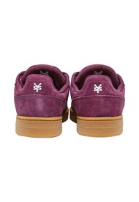 Lilla ruskindsneakers med en gummisål, der har et hvidt logo på hælen, polstret krave og tekstureret indersål.