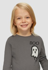 Graues Langarmshirt mit dem Wort "BOO" in Schwarz und einer weißen Gespenstgrafik auf der Vorderseite. Hergestellt aus weichem Baumwollmaterial.