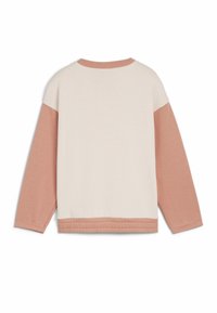 Ljusbeige tröja med långa ärmar i mjuk rosa. Har en rund halsringning, elastisk midja och en färgblockeringsdesign på ärmarna.