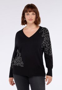 Maglione nero a V con maniche lunghe, caratterizzato da un motivo a stampa leopardata in paillettes argento sul lato sinistro e sulla spalla. Texture liscia.