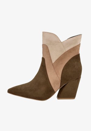 Botín de ante con punta afilada, que presenta un diseño a bloques de color en beige, marrón claro y marrón oscuro. Tacón grueso y texturizado.
