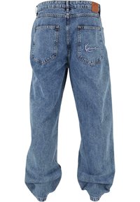 Light blue denim jeans with a relaxed fit, featuring two back pockets, a leather patch on the waistband, and subtle embroidered detailing.