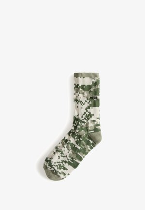 Groen-witte digitale camouflerende crew-sok met geribbelde structuur, verstevigde teen en Vans-logo aan de zijkant.