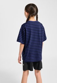 Marineblauw gestreept T-shirt met korte mouwen, gemaakt van zachte stof, gecombineerd met zwarte shorts met een klein grafisch detail.