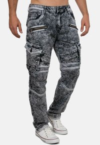Jeans cargo in denim nero sbiadito con numerose tasche con zip, finitura testurizzata, vestibilità slim e dettagli di cucitura a contrasto.