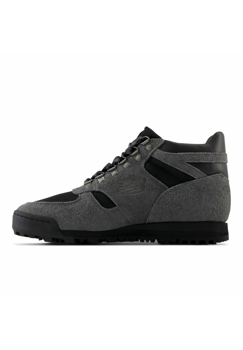 Grijze hoge sneakers met suède en mesh materialen, voorzien van een gevoerde kraag, vetersluiting en een geprofileerde loop zool van rubber.