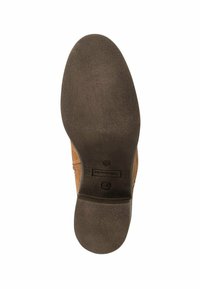 Semelle de chaussure en cuir marron avec une forme arrondie, une surface texturée et une finition lisse. Présente une empreinte de logo près du talon.