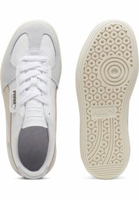 Białe sneakersy z zamszowymi i siateczkowymi akcentami, okrągły czubek, teksturowana szara wkładka oraz wzorzysty gumowy bieżnik. Logo Puma z boku.