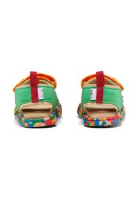 Sandalias de ante verde con acentos naranjas, parte trasera abierta y suelas con patrones coloridos, que cuentan con correas de velcro rojas para un ajuste seguro.