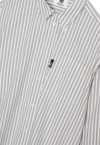 Button-up shirt with vertical gray and white stripes, featuring a pocket, rounded collar, and a black label detail on the chest.